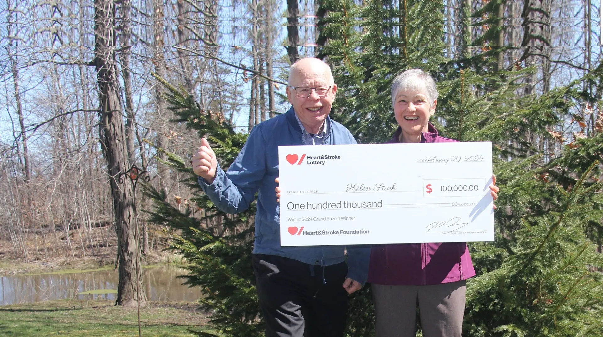 Helen Stark and her husband hold a giant cheque for $100,000